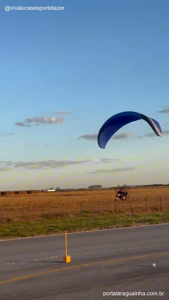 Paramotor voando sobre pista de corrida