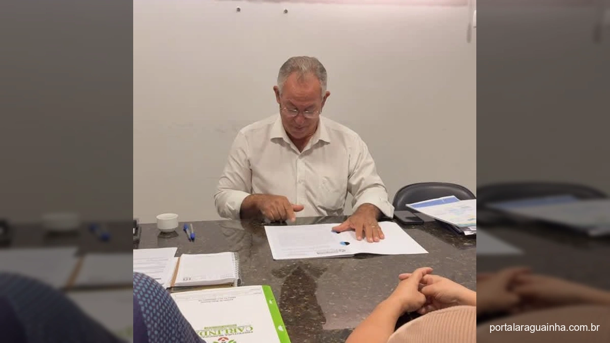 Prefeito de Carlinda e membros da Associação de Recicláveis ARCA assinando documento sobre a doação de terreno para atividades de reciclagem.