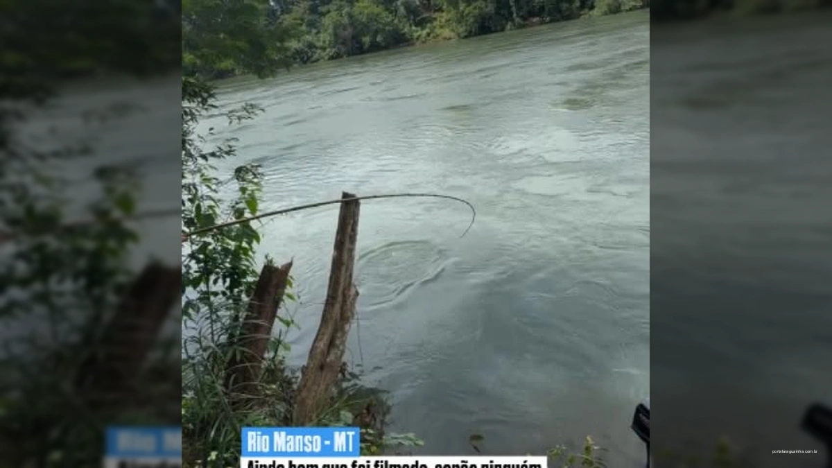 Pescador com vara de bambu e dourado pulando na água.