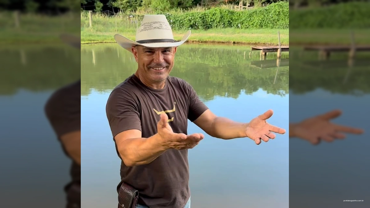 Homem sorrindo com chapéu de cowboy em frente a um lago recém-construído