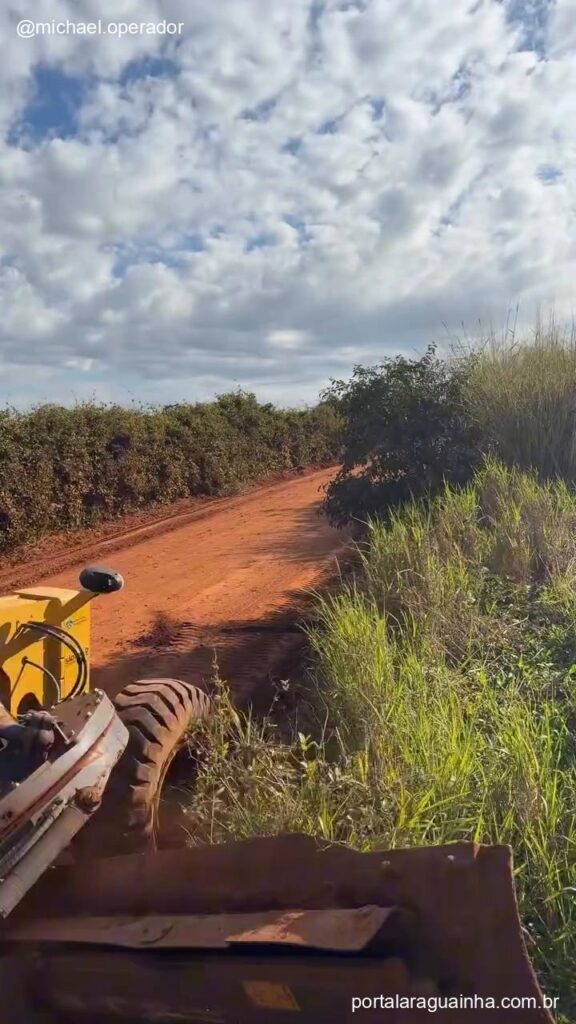 Maquina patrola alargando curva estrada rural