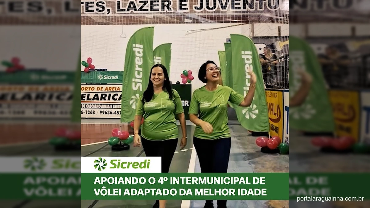 Pessoas da melhor idade jogando vôlei adaptado com torcida e representantes do Sicredi.