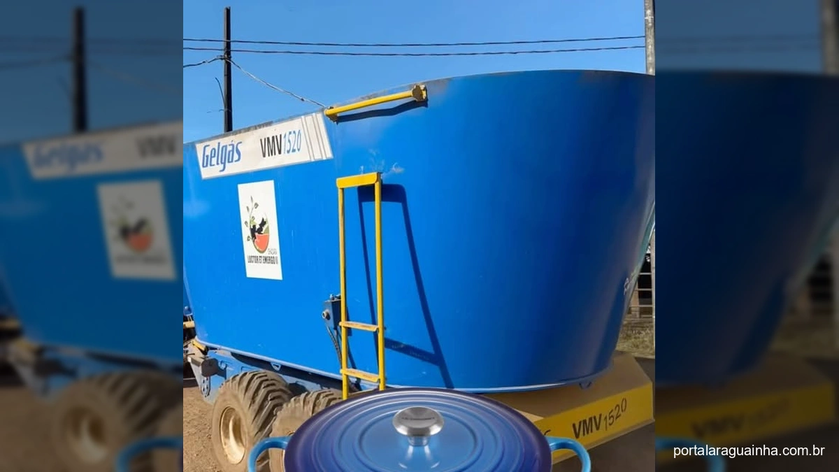 Vacas leiteiras em instalação moderna com ventiladores e máquina de alimentação